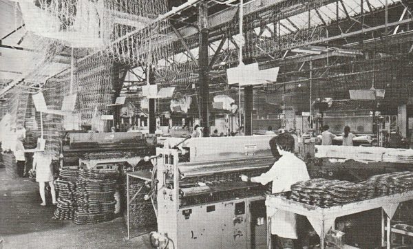 Treca Paris artisan operating an industrial sewing machine in the mattress workshop.